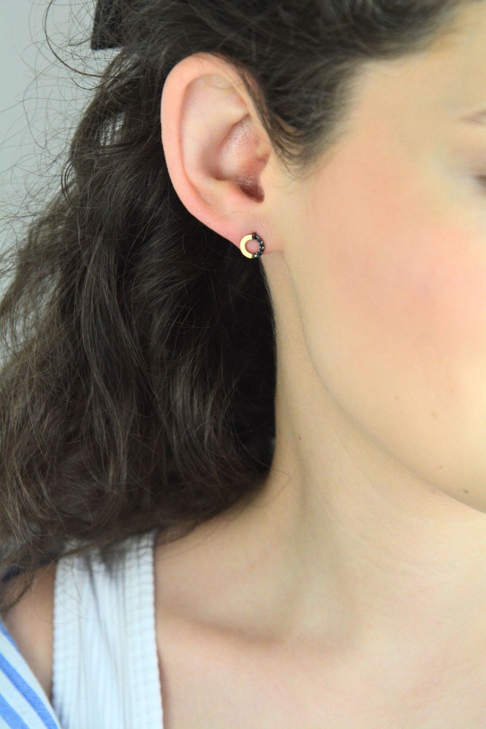 Złote kolczyki celebrytki przy uchu z czarnymi kamieniamisds.jpg